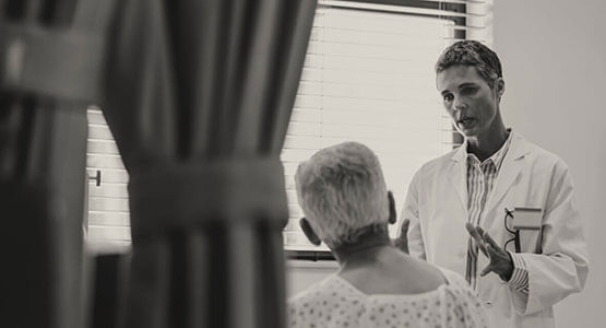 Hospital medicine clinician speaking with patient Hospital medicine patient flow case study image